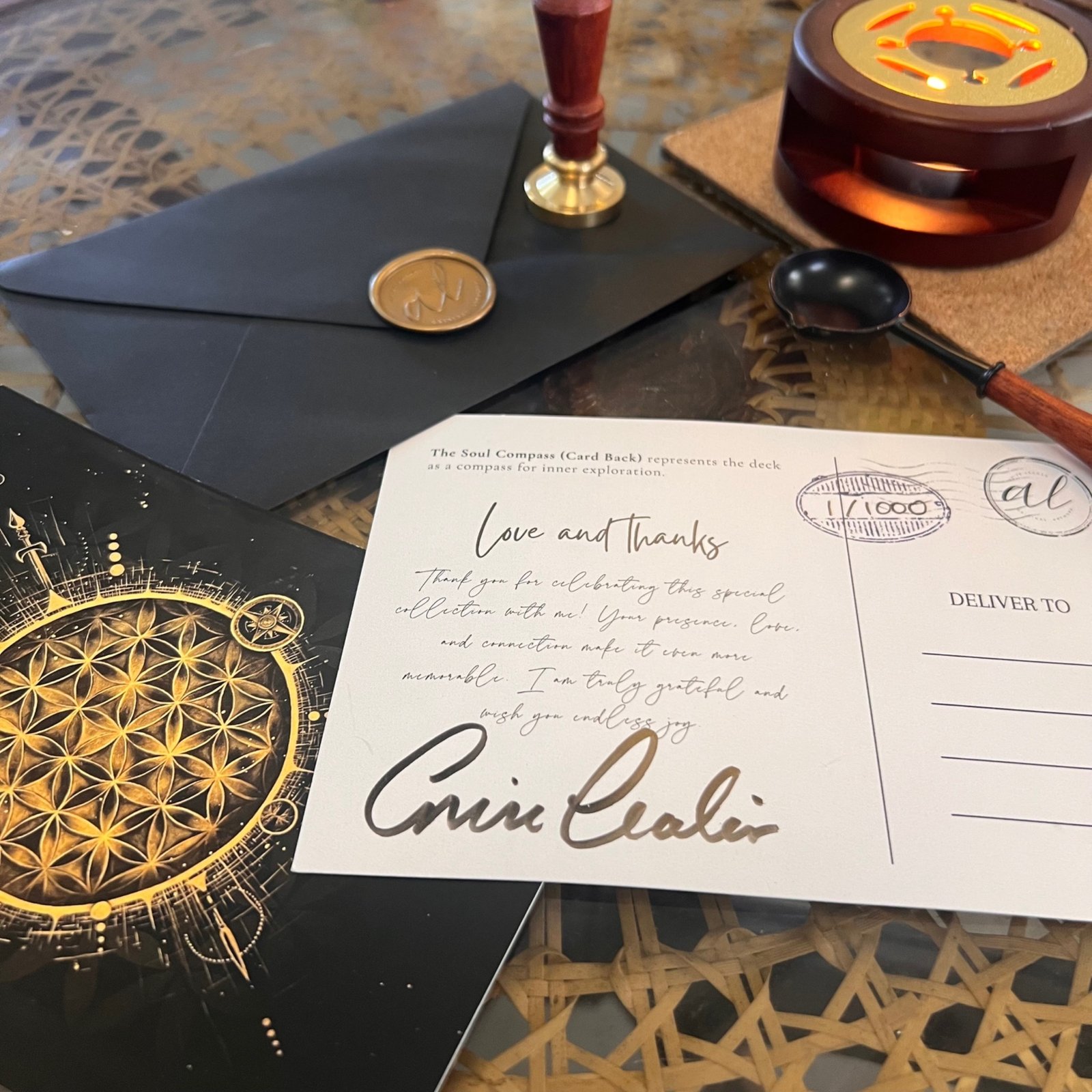 The Soul Compass A6 collectible postcard displayed with its black envelope.